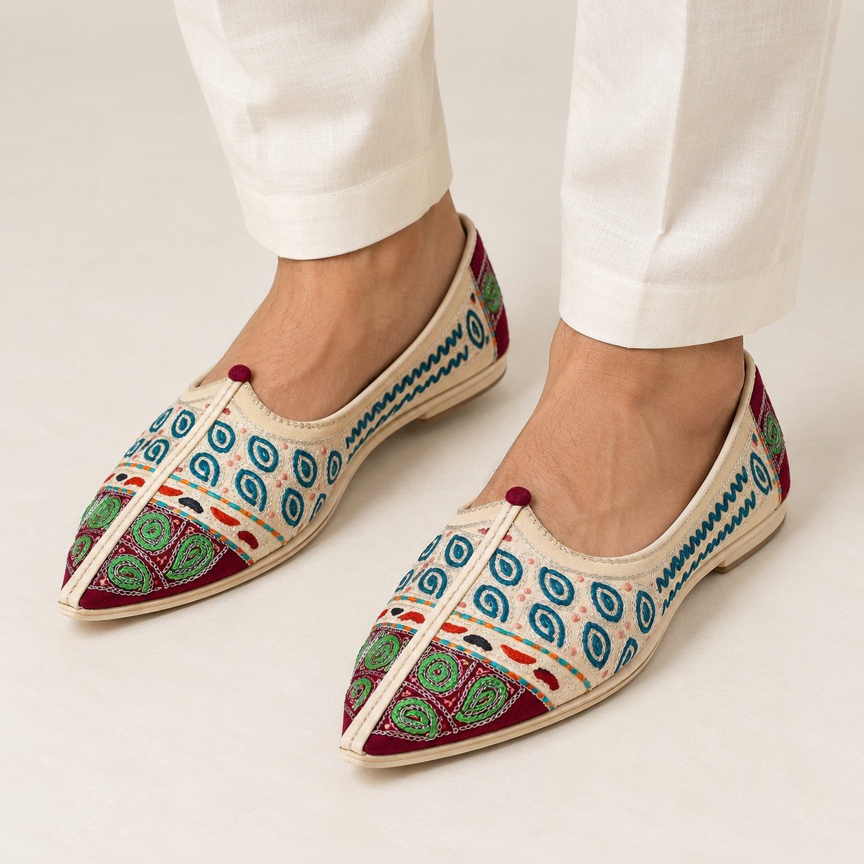 MyMarwar beige, burgundy, green and teal mojari for men with paisley and spiral embroidery, worn with an ethnic outfit